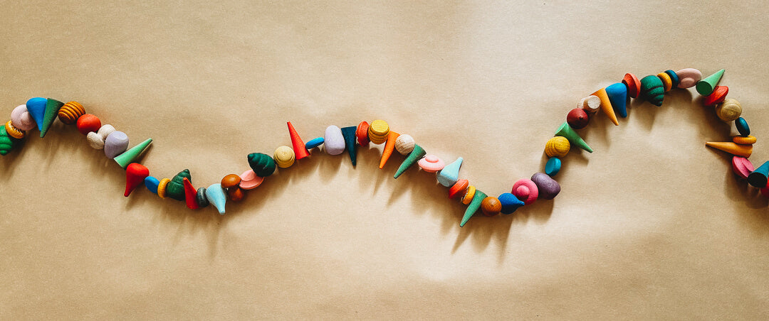 A garland of Grapat loose parts on a brown paper background