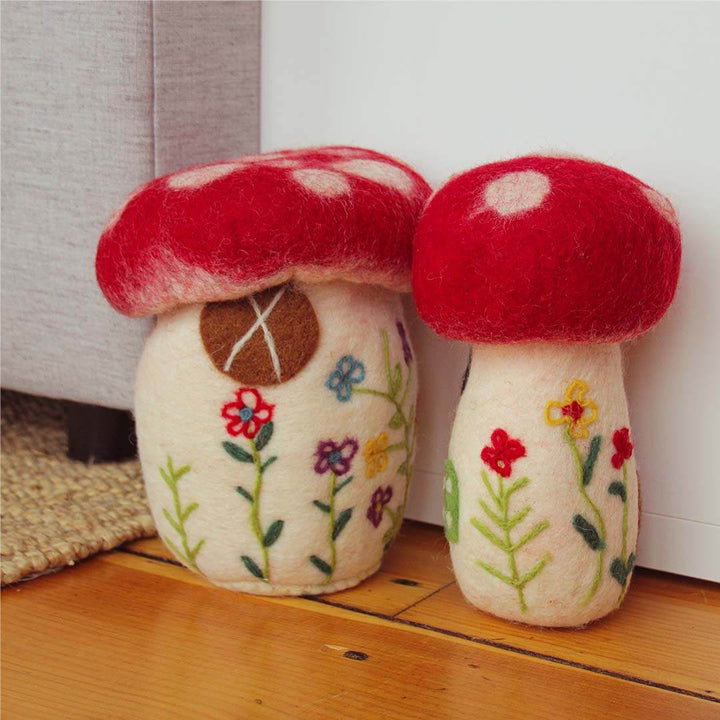 Set Of Two Felted Mushrooms on a hardwood floor.