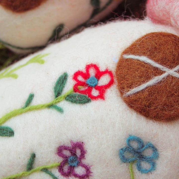 Up close view of an embroidered felt mushroom.