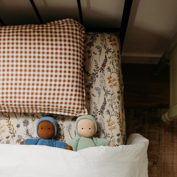 Two Bella Luna Waldorf Dolls tucked into a child's bed.