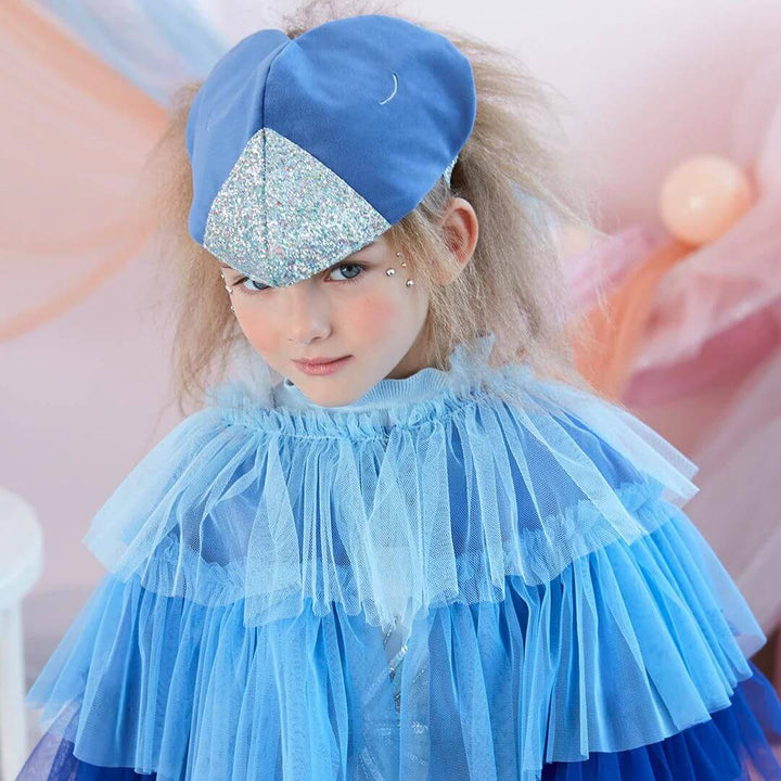 A child wears the velvet head piece and tulle cape from the Blue Velvet Bird Costume.