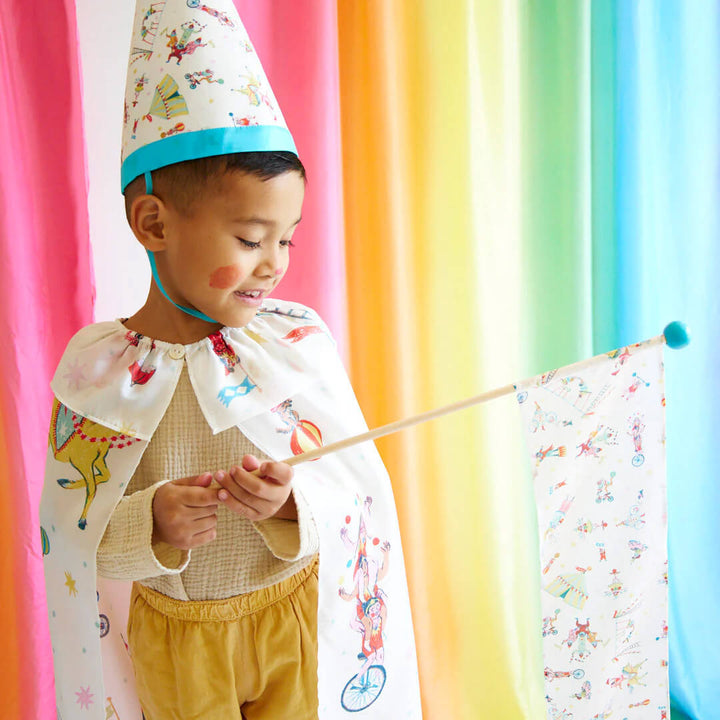 Boy wearing Sarah's Silks Silk Circus Hat, Circus Cape, and holding Circus Silk Wand