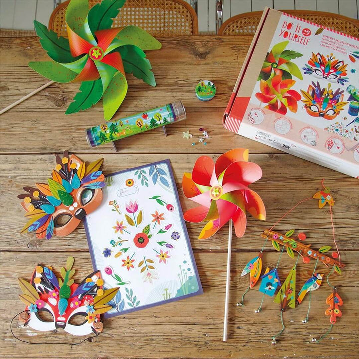 Crafts from DIY Nature Multi Activity Craft Kit on a wooden table including 2 masks, 1 chimes, 2 windmills, 1 nature poster, 1 kaleidoscope