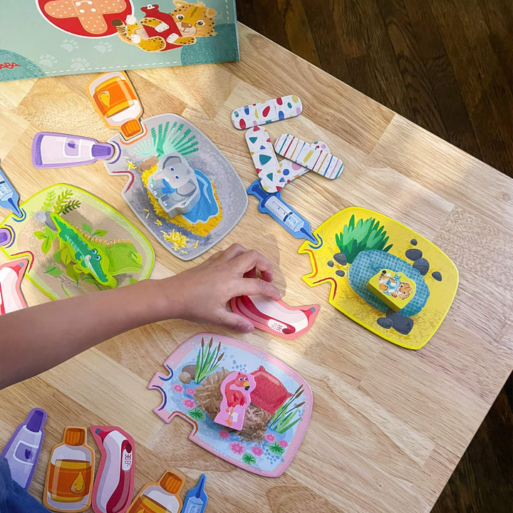 A child places a game piece on the board for the Let's Be Veterinarian's game from HABA.