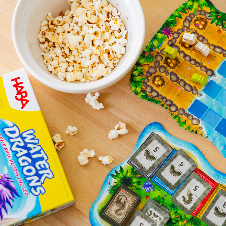 Components of Water Dragons game including game board, wooden dragon pieces, and cards.