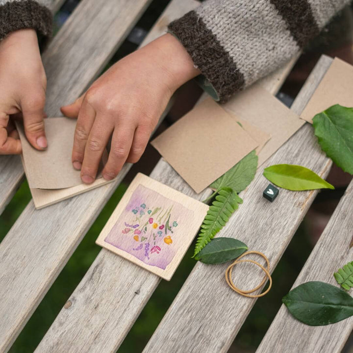 A childs hands assembling a mini wooden leaf press from the 2024 Grapat Advent Calendar.