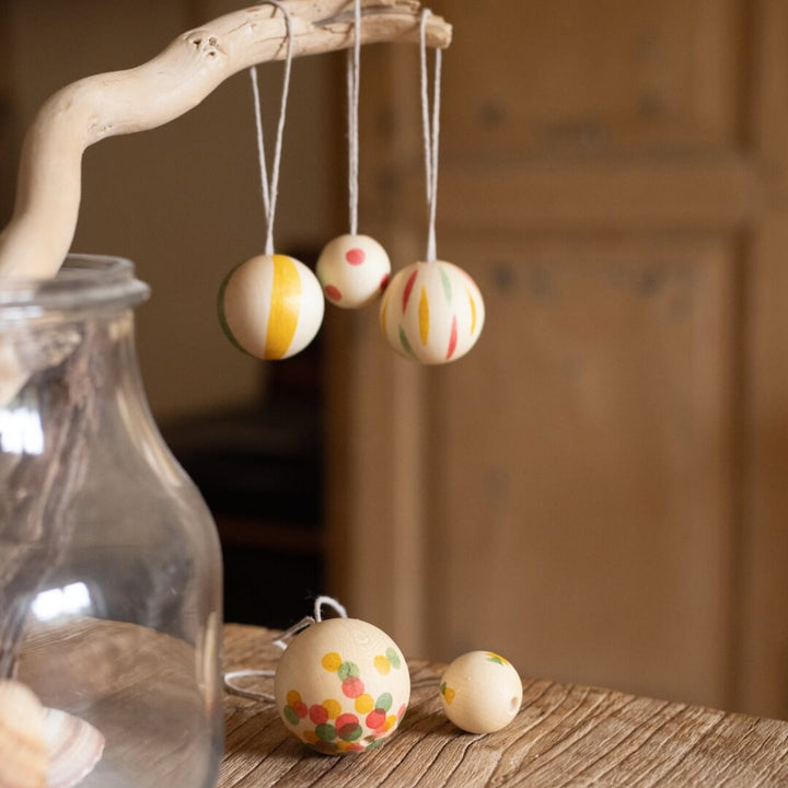 Grapat Wonder Balls wooden ornament set hanging from a branch in a vase.