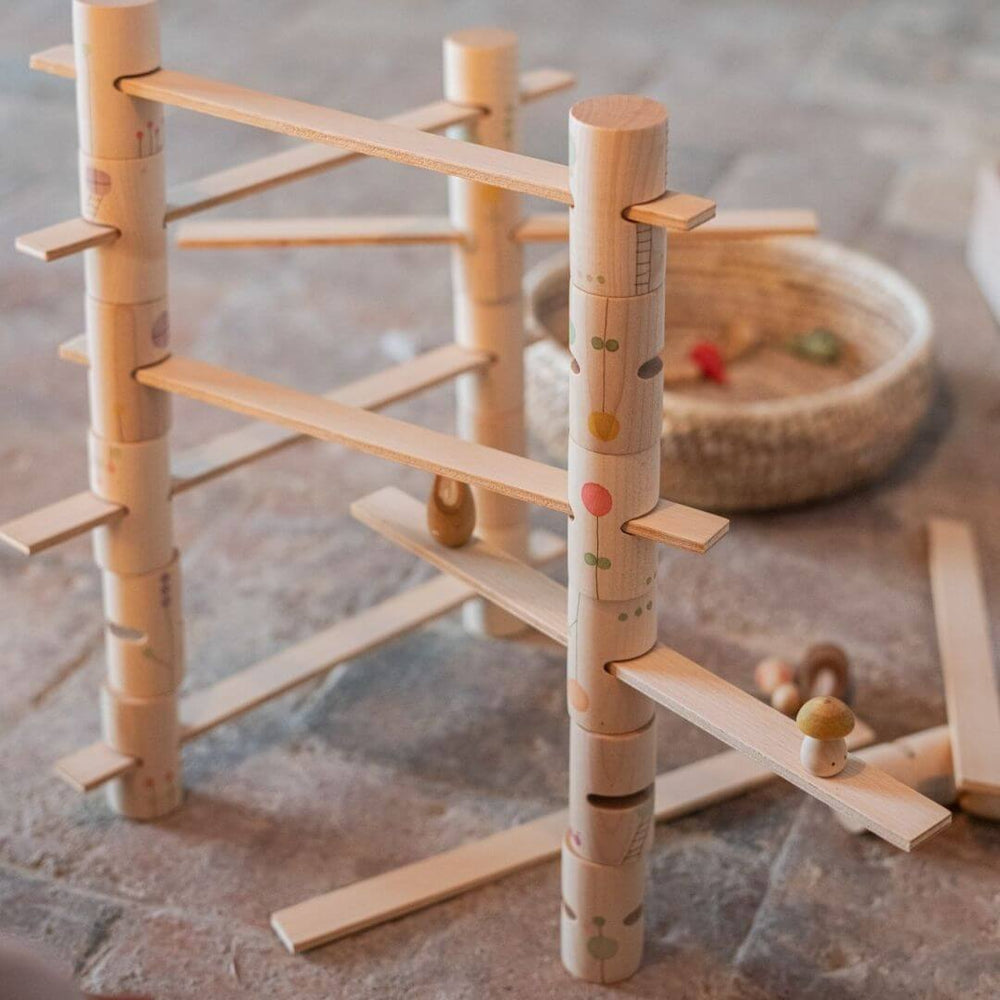 Grapat Woodland Stacking Tower Set with hand-painted wooden tubes and walkways, set up with other wooden toys for open-ended building and imaginative play.