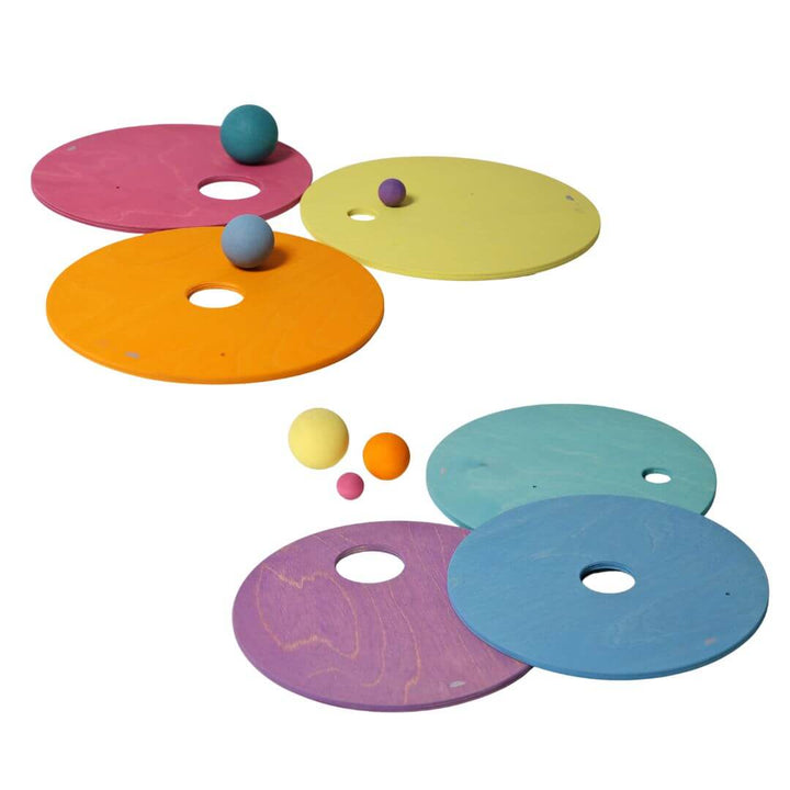 6 wooden pastel rainbow discs with various sized holes and wooden balls.