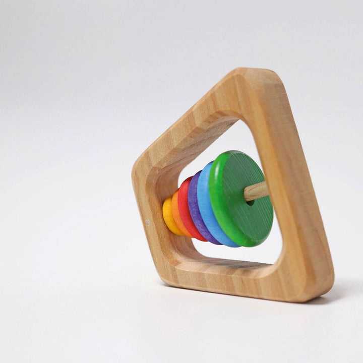 Grimm's Wooden Rainbow Pyramid Rattle - a natural base with green, blue, purple, red, orange, and yellow round discs that comprise the rattle - from the side