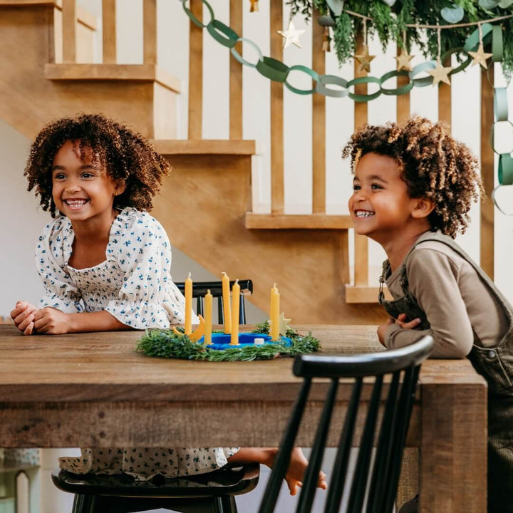 Two children laughing at a table decorated with the Grimm's Over the Moon Celebration Ring.