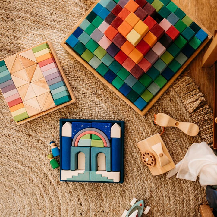 A Grimm's Large Stepped Pyramid block set next to other assorted toys from Grimm's.