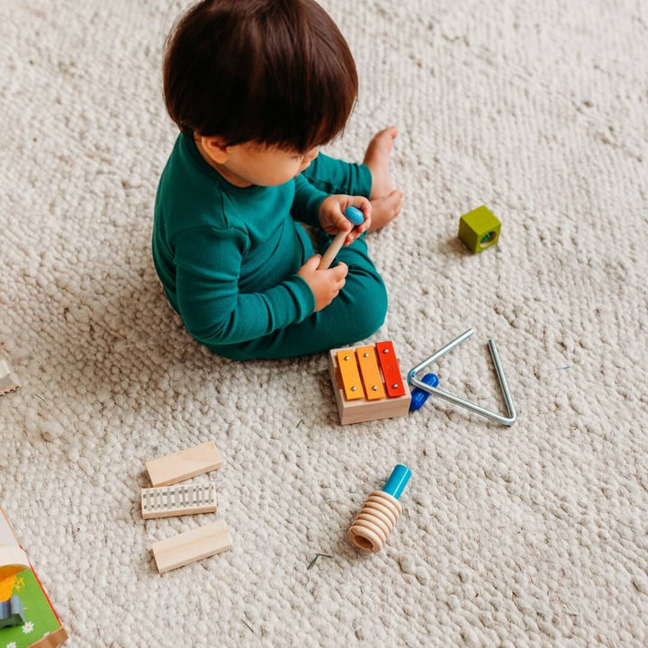 A child playing with the HABA Musical Joy play set.