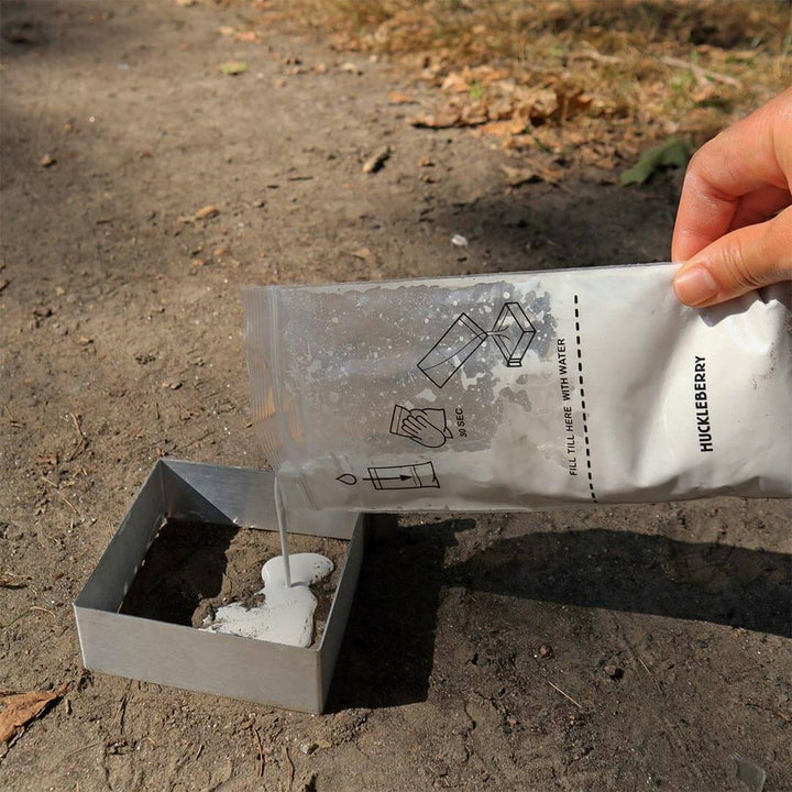 A hand pouring the material into a track on a trail in the mold with the Huckleberry Cast a Track kit