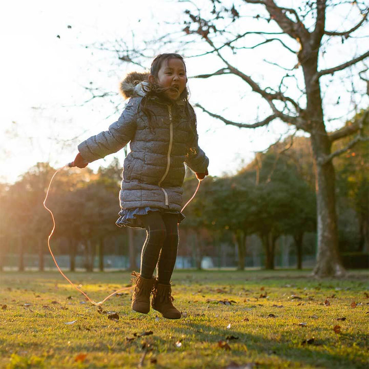 Girl in gray jacket skipping rope with red Huckleberry Skipping Rope