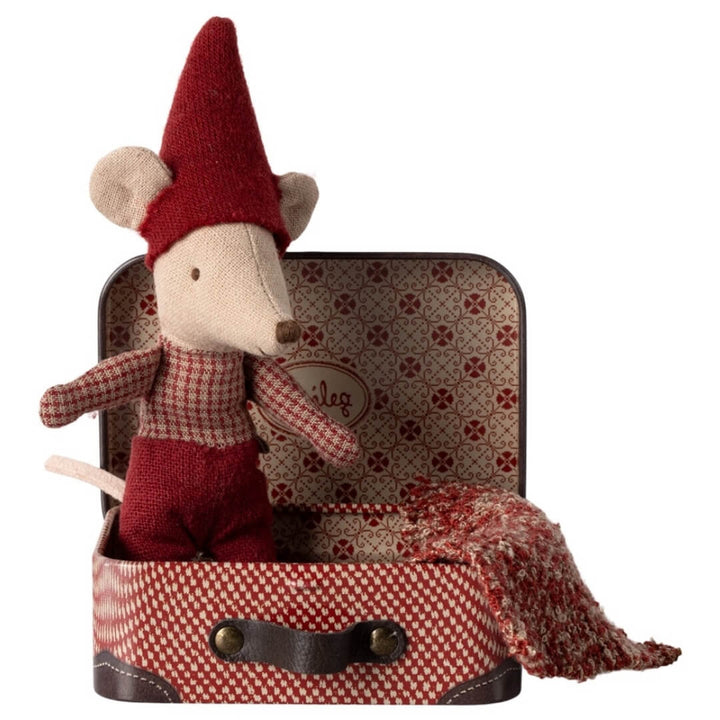 A baby Maileg mouse with a pointy red cap, red pants and plaid shirt sits inside a red plaid suitcase.