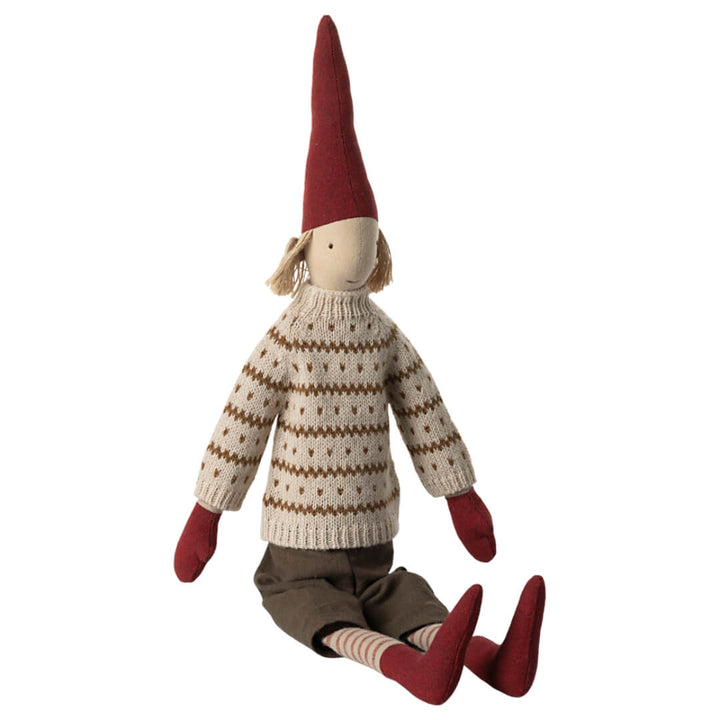 Pixy Boy wearing brown shorts, red mittens and stockings, and red pointed hat with blonde hair and cream knit sweater with gold stripes and polka dots, sitting.