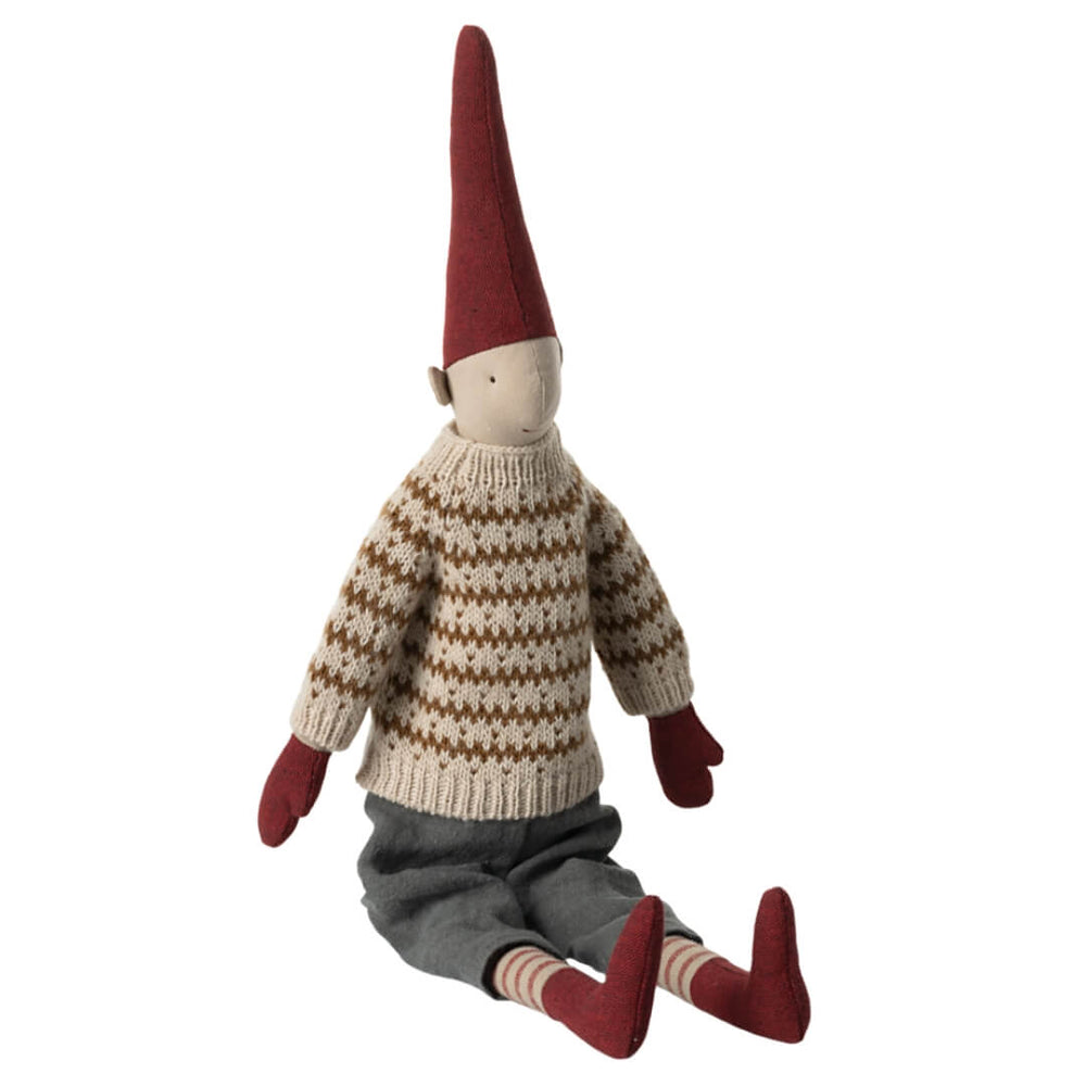 Maileg medium Pixy Boy - sitting and wearing a stripped knit sweater, grey linen pants and red mittens, socks and pixy cap.