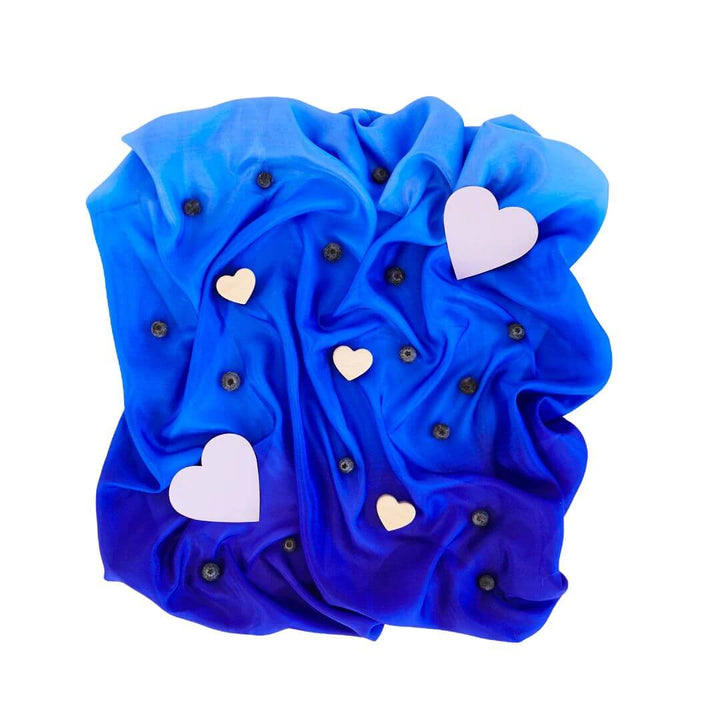 A royal blue ombre playsilk with blueberrie and white hearts scattered ontop of it.