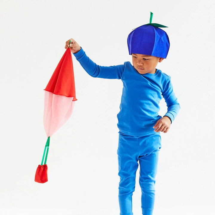 A child in a blueberry costume holding the pink and red silk strawberry parachute.