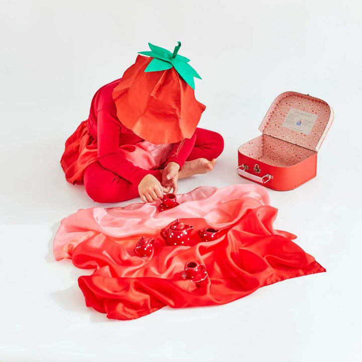 A child in strawberry costume having a tea party with the Sarah's Silks Strawberry Blend playsilk.